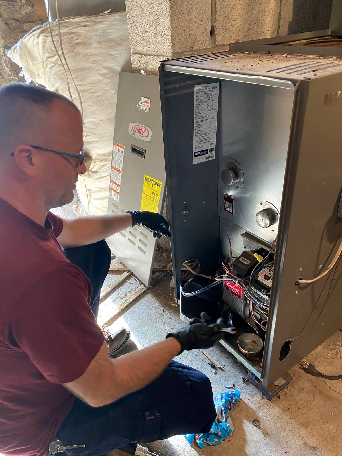 Aurora HVAC technician inspecting an open furnace
